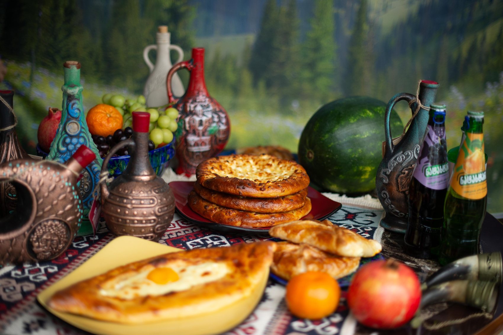 A Georgian supra spread — khachapuri, fruit, and wine